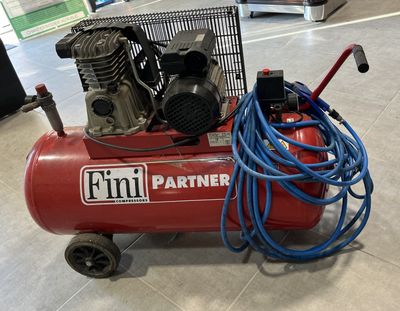 a red air compressor sitting on top of a cart