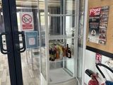 une vitrine située dans un coin d'un magasin, avec un extincteur
