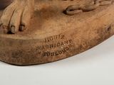 statue of a dog on a wooden base with a paw on it ' s foot
