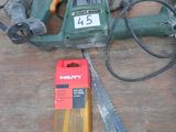a drill, a saw, and some other tools on a table