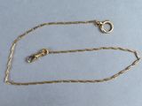a close up of a gold chain with a clasp on a blue surface