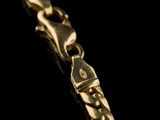 a close up of a gold chain on a black background
