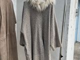 two coats hanging on a clothes rack outside of a building