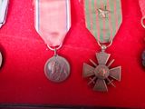 several medals and medals are displayed on a red display case