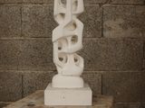 a white sculpture sitting on top of a wooden table