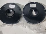 two spools of black pla filamant on a table