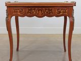 une table ancienne en bois, avec un plateau et des pieds sculptés