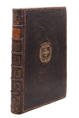 un vieux livre orné d'un emblème doré sur la couverture