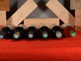 bottles of wine are lined up on a red table cloth