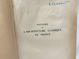 un livre ouvert sur une table, sur lequel est posé un bout de papier