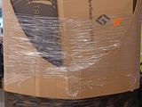 un grand carton posé sur une palette dans un entrepôt