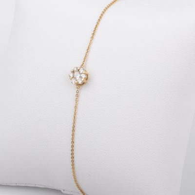 a gold chain bracelet with a flower charm on it