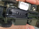 a person holding a toy army vehicle in their hand