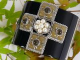an image of a black and white bracelet with pearls on it