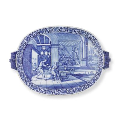 une assiette ovale bleue et blanche sur laquelle est représenté un homme et un chien