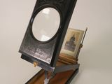 une petite boîte noire sur laquelle est posée une loupe