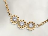 un gros plan d'un collier en or orné de trois diamants
