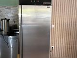 a stainless steel refrigerator in a kitchen with a coffee maker on the counter