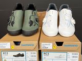 trois paires de chaussures posées sur des cartons, sur une table