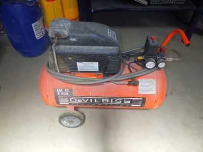 un petit compresseur d'air posé par terre dans le garage