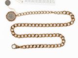 a gold chain with a coin on it next to a piece of paper