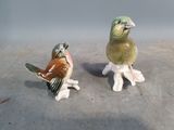 deux figurines représentant des oiseaux posés par terre