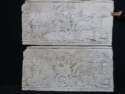 un homme qui se tient à côté d'une sculpture en pierre