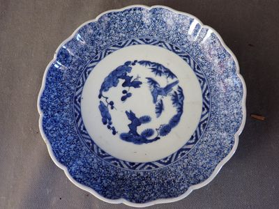 une image représentant une assiette bleue et blanche ornée d'un dragon
