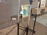 un porte-objets en métal surmonté d'un miroir, placé dans un coin de la pièce