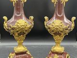 une paire de vases rouges et dorés posés sur une table