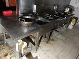 une photo d'une cuisine avec de nombreuses casseroles et poêles posées sur le plan de travail