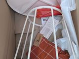 a white metal bed with a basket on top of it