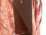 an orange dress with a black tag hanging from it ' s side