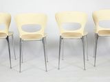 four yellow chairs sitting in a row against a white wall