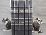 five books sitting on top of each other on a table