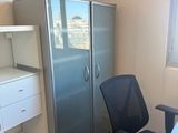 un bureau avec une chaise et un réfrigérateur dans un coin