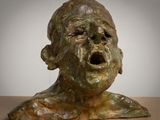 sculpture en bronze représentant le visage d'une femme, la bouche ouverte