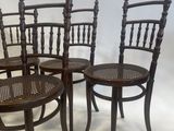 four wooden chairs are lined up in a row on a white background