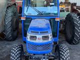 un tracteur bleu garé dans un bâtiment