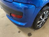 the rear end of a blue car in a showroom