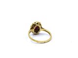 an image of a close up of a gold ring with a red stone