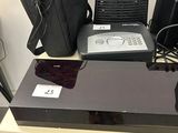 a lot of electronics sitting on a table with a bag