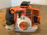 an orange and black chainsaw sitting on top of a wooden floor