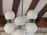 un lustre composé de boules de verre blanc suspendues au plafond