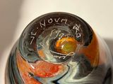 a glass vase with an orange and black design on it