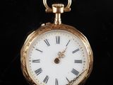 une montre de poche en or avec des chiffres romains sur le cadran