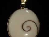 une photo d'un pendentif orné d'un motif en spirale