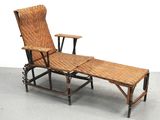 une chaise longue en osier avec une table en dessous