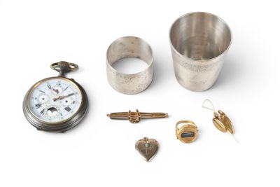 a silver cup, a pocket watch, a ring, and other items on a white surface