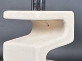 une table en béton blanc sur laquelle est posée une lampe